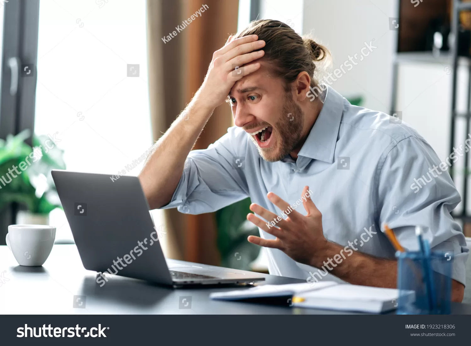 stock-photo-shocked-annoyed-caucasian-busy-guy-looking-at-a-laptop-in-confusion-received-unexpected-news-1923218306
